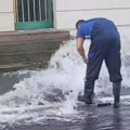 Gejzir izvire iz ulice na Zvezdari: Muškarac se u gumenim čizmama bori sa vodom