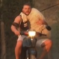 (Video) Ova fotografija iz Grčke oduševila svet: Mladić sa ovcom u naručju na motoru prolazi kroz vatru i dim postao je simbol…