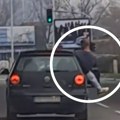 Čovek izgubio razum u Beogradu: Zajahao vrata automobila u pokretu, telo i noga vire mu kroz prozor