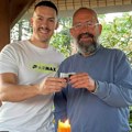 "Srećna slava domaćini" Baka Prase nazdravlja sa ocem sveštenikom ispred ikone: na stolu bure, sveća i slavski kolač