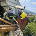 Pripadnici Uprave za vanredne situacije i vatrogasci-spasioci pomažu sugrađanki u prepokrivanju krova kuće
