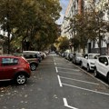 Fotografija parkinga na Dorćolu pored koga ljudi prolaze, gledaju automobile i krste se