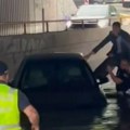 Dramatičan snimak iz Beograda: Policajci spašavaju zaglavljenog čoveka u vozilu ispod mosta (video)