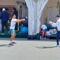 Novak se zagreva za meč - neočekivan susret FOTO