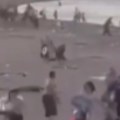 Plaža u Sevastoplju zasuta bombama Muškarac vuče dete na zemlju i zaklanja ga (video)