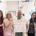 Gde je medicinska etika? Lekar u Tiršovoj se slikao sa sramnim transparentom FOTO