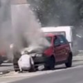 Gori auto nasred puta: Vatra guta vozilo u Bačkoj Palanci, prolaznik i vozač pokušavaju da obuzdaju plamen